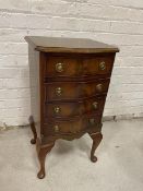 A Georgian style mahogany bedside chest of drawers with serpentine canted fronted top over four