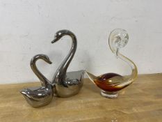 A cased glass figure of a swan, measures 20cm high, and a metal figure of two swans (2)