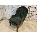 A Victorian walnut nursing chair with buttoned back and arms over sprawled and carved arms and