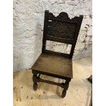 An early 19thc oak side chair with carved top rail and panel back on turned front supports united by