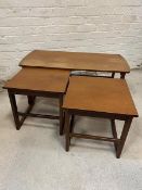 A mid century set of three teak nesting tables, the rectangular top with two matching nesting tables