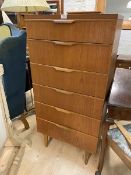 A mid century teak tall chest of six drawers on turned supports, (127cm x 61cm x 44cm)