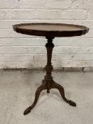 A Reprodux mahogany Georgian style wine table with pie crust top on turned stem, tripod support