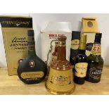 A group of four bottles including a Janneau Grand Armagnac Fondateur VSOP, a Bells Scotch Whisky