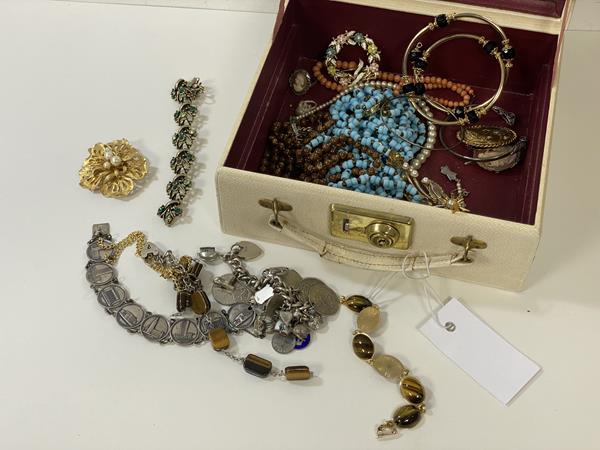 A collection of silver and costume jewellery including a chain with silver charms, a Swedish