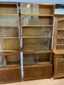 A Minty oak sectional bookcase with five tiers, having sliding glass doors, on base