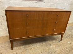 A mid century teak chest of drawers the rectangular top with concave front, over two short drawers