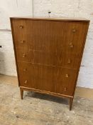 A mid century teak chest of drawers, the rectangular top with concave front, over five graduated