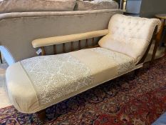 A late Victorian walnut framed chaise long, upholstered in floral damask, arm rest raised on spindle