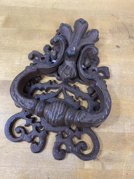 A cast iron pierced door knocker, (19cm x 13cm)