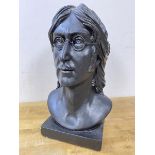 A plaster bust of John Lennon, painted black, on square base, measures 35cm high