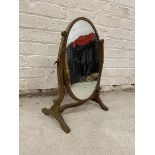 A mahogany dressing table mirror the oval glass on C scroll supports with trestle base,