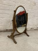 A mahogany dressing table mirror the oval glass on C scroll supports with trestle base,