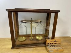 A vintage set of balance scales in display case marked Sold by A H Baird Edinburgh, and a box of