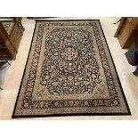 A machine made Persian style carpet, the field with foliate design within multiple floral