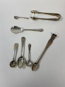 A group of four London silver spoons including a Georgian condiment spoon, a Victorian condiment