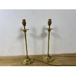 A pair of brass candlestick style tablelamps raised on circular bases, measures 40cm to top of