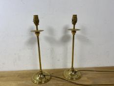 A pair of brass candlestick style tablelamps raised on circular bases, measures 40cm to top of