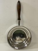 A white metal plated pan with gadrooned edge and turned wooden handle, measures 6cm x 55cm x 28cm