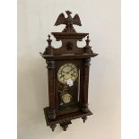 A German 20thc wall clock, the superstructure with carved bird over face mask and urn finial's