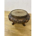 A Chinese circular stand with pierced apron on four C scroll supports, likely a lamp base, (12cm x