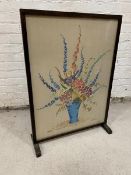 A 1930's / 40's floral embroidered panel within glazed fire screen,