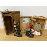 Two vintage microscopes with original boxes, one box with label Studio Mikroskope, and a copy of The