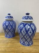 A pair of modern blue and white lidded baluster shaped jars, each with a repeating lozenge floral