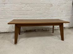 A mid century teak coffee table, the rectangular top on angled tapering supports measures 37cm x