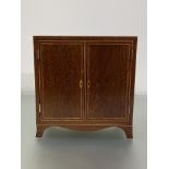 A George III crossbanded and string-inlaid partridgewood table cabinet, c. 1800, the case with a