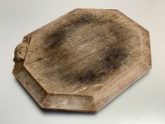 Workshop of Robert (Mouseman) Thompson, a shaped octagonal oak cheese or bread board, with carved