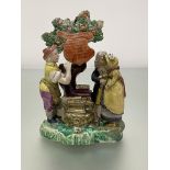 A Staffordshire pearlware Gretna Green figure group, c. 1820, the couple standing before a