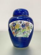 A Chinese porcelain jar and cover, painted with a pair of fan-shaped cartouches, enamel painted in a