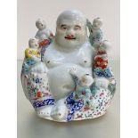 A Chinese famille rose porcelain group of a laughing Buddha with five children, the unglazed base