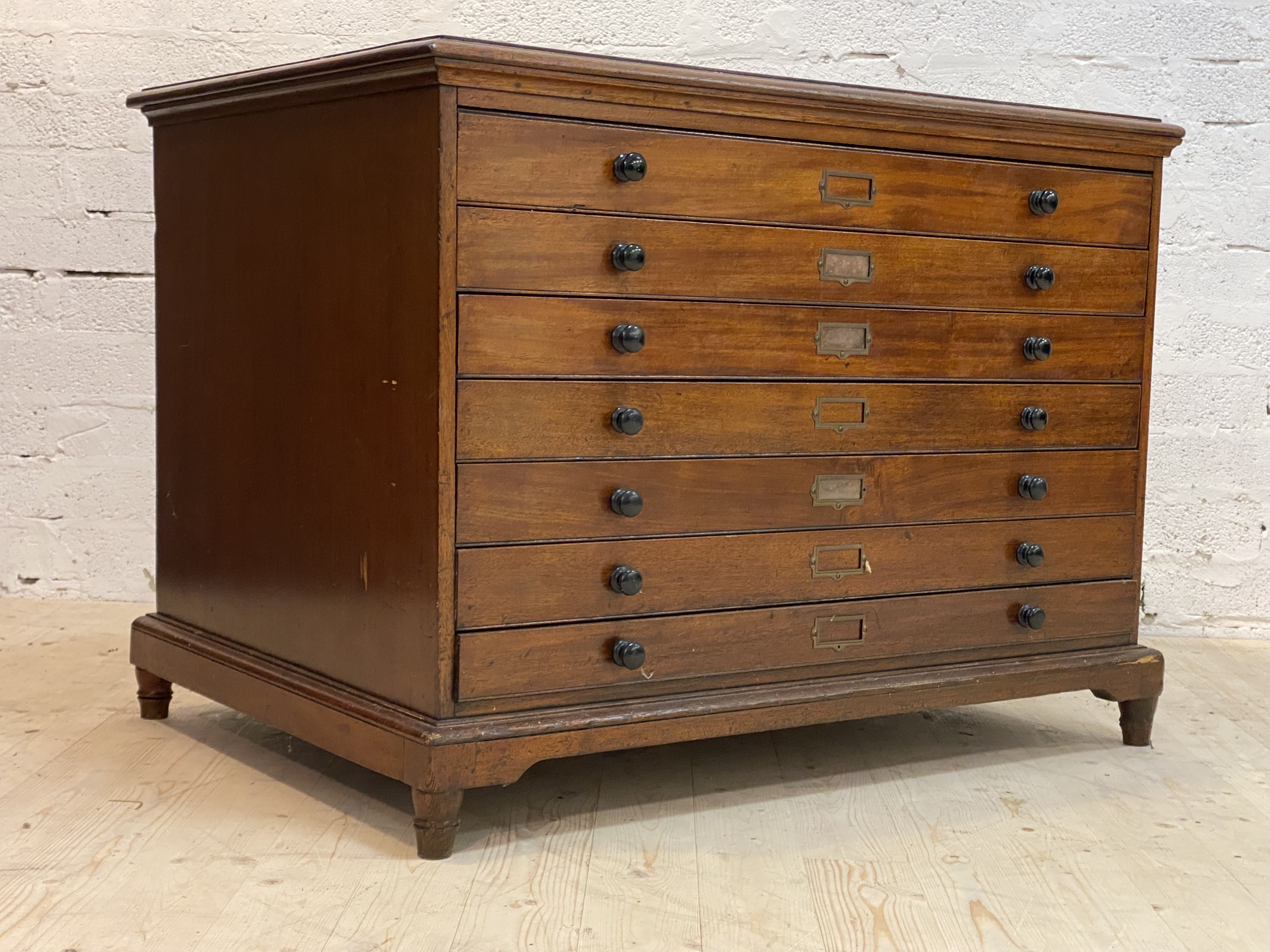 A late 19th century mahogany plan chest, the moulded top over seven drawers, each with ebonised pull