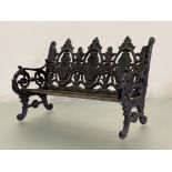 A miniature cast iron bench after a Coalbrookdale design, with slatted wooden seat. 27.5cm by 41cm