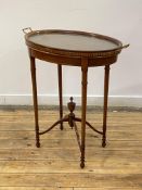An Edwardian mahogany occasional table of oval outline, the lift off tray top with twin gilt brass