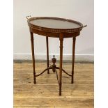 An Edwardian mahogany occasional table of oval outline, the lift off tray top with twin gilt brass