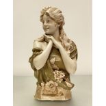 A Royal Dux porcelain bust by Herman Schubert, modelled as a girl looking dexter, a corsage at her