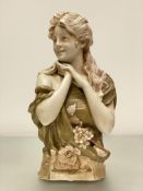 A Royal Dux porcelain bust by Herman Schubert, modelled as a girl looking dexter, a corsage at her
