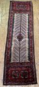 An Iranian runner rug, hand knotted thick wool pile, the ivory field centred with gul, with two