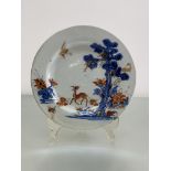 A Chinese porcelain plate decorated in an Imari palette with a deer beside a pine tree, with a crane