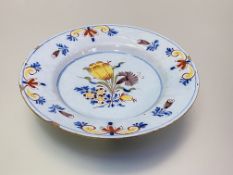 An English Delft plate, 18th century, possibly Liverpool, polychrome painted in "Fazackerley"
