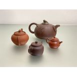 A Chinese Yixing red stoneware teapot modelled as a pumpkin with leaves in relief and with carved