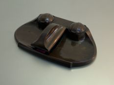 A patinated bronze desk standish, early 20th century, possibly German, of shaped oval form, with