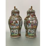 A pair of 19th century Canton famille rose vases and covers, of baluster shape, each decorated