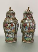 A pair of 19th century Canton famille rose vases and covers, of baluster shape, each decorated