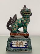 A Chinese famille verte model of a Buddhistic lion, modelled seated on a plinth with Chinese