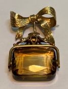 A 9ct gold and citrine brooch, formed of a swivelling fob suspended from a ribbon-tied brooch,