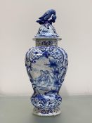 A Dutch Delft vase and cover, late 19th century, of baluster form, painted and moulded with